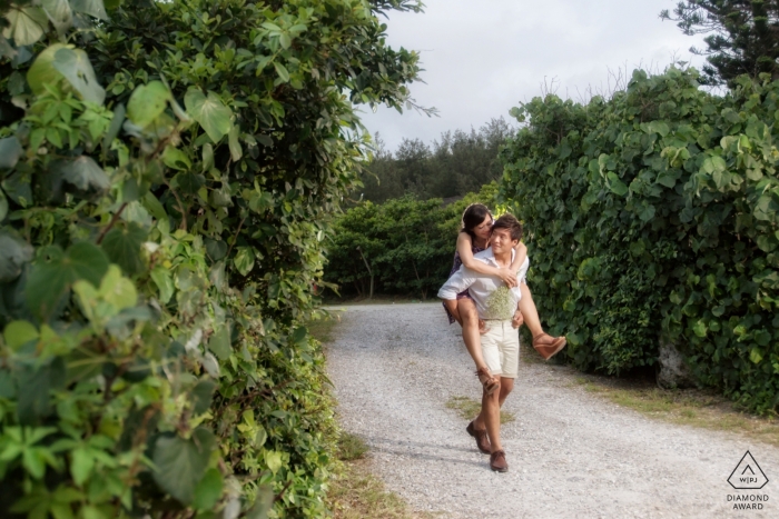Photo by: <a href="https://www.wpja.com/photos/diamond-award-top-wedding-engagement-photographer/2497381">Tao-Hsuan Tzu - Ji’an Township, Hualien County A man carries his fiance along a path through tall, green bushes in this engagement photoshoot by a Hualien County, Taiwan photographer.
