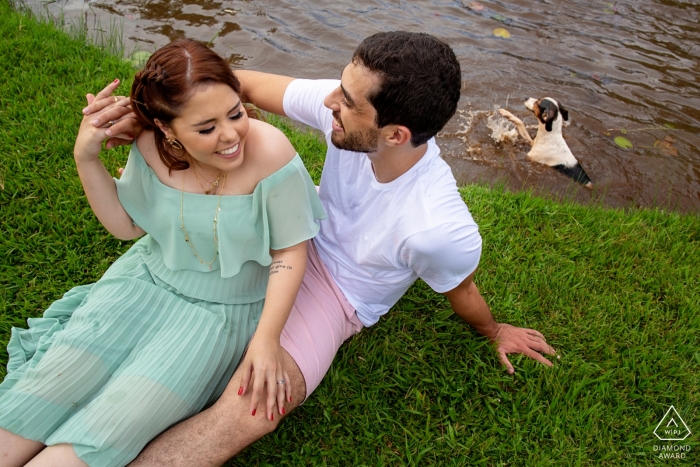 O casal de noivos senta e sorri durante sua sessão de pré-casamento