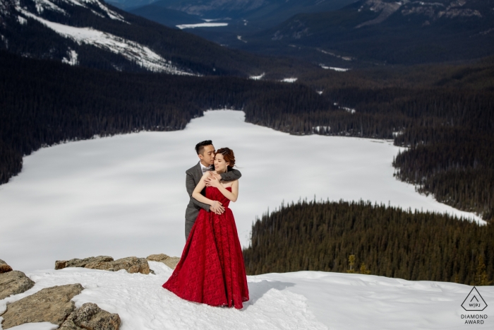 Photo by: <a href="https://www.wpja.com/photos/diamond-award-top-wedding-engagement-photographer/2498121">Dorota Karpowicz - Edmonton Alberta Banff National Park, AB, Canada engagement photographer captured this photo of a couple embracing on top of a snow covered mountain