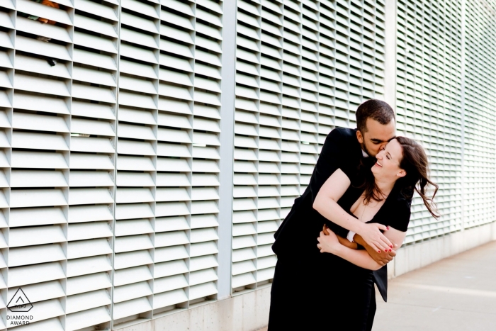 Zaangażowana para ściska się w Modern Chic North Loop Minneapolis Urban Engagement Shoot z Cool Texture Wall