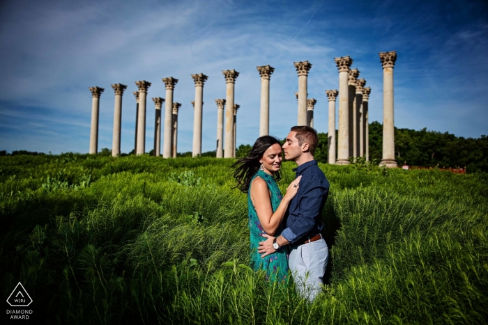 Couple engagé dans un champ pour sa session d'engagement de CD