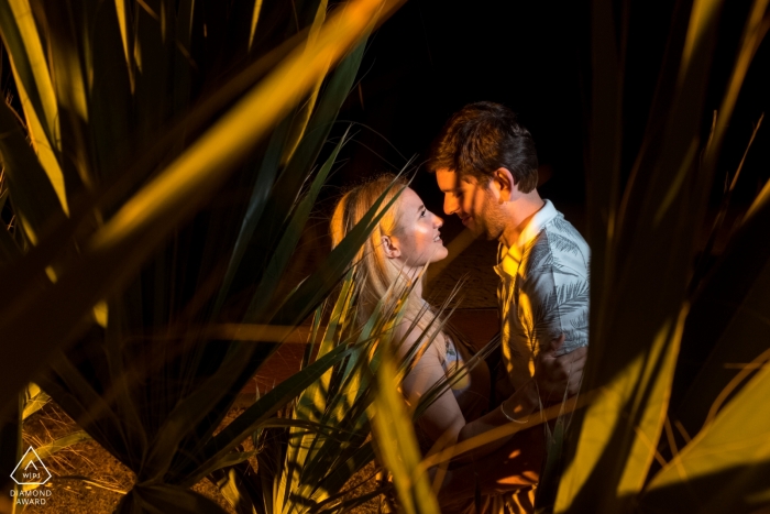 Foto: <a href="https://www.wpja.com/photos/diamond-award-top-wedding-engagement-photographer/2501441"> Orçun Yalçın - Ankara Ankara Enagaged-Paare, die einander hinter einer Palme nach ihrem Verlobungstrieb betrachten