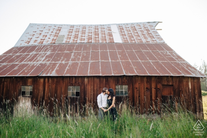 Enumclaw, WA Séance de portrait avant mariage | Un couple nouvellement fiancé baise à côté d'une grange