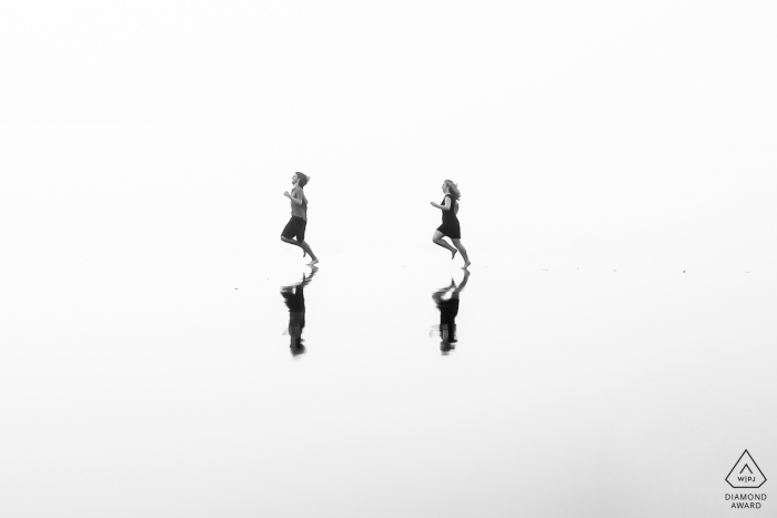 Northern California - beach reflection of couple running for engagement shoot
