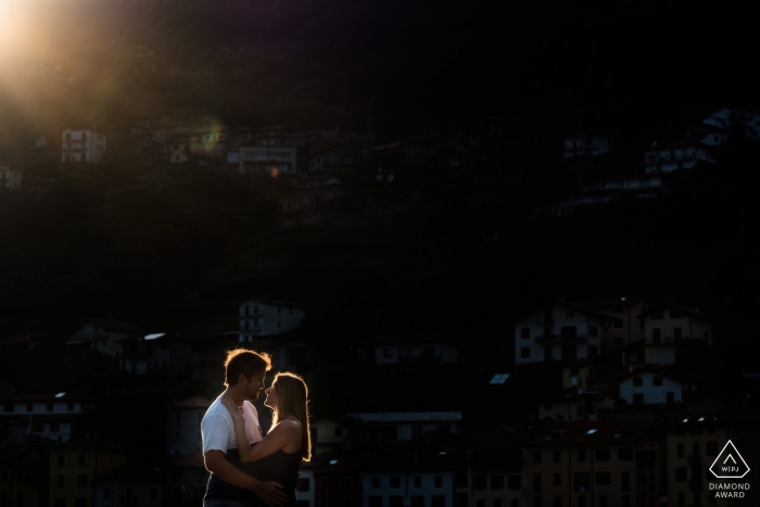 Flanders fotógrafo de noivado tirou esta foto do casal se beijando enquanto o sol brilha sobre eles durante uma sessão de fotos perto de Musso