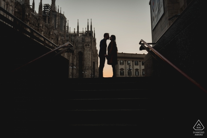 Photographie de fiançailles à Naples représentant un couple s'embrassant dans une cage d'escalier d'une ville de Milan au crépuscule