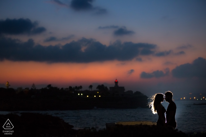 Die Sonne ist untergegangen, aber das Paar wird von einem Licht auf dem Dock in diesem Fotoshooting vor der Hochzeit in Siracusa beleuchtet Die Sonne ist untergegangen, aber das Paar wird von einem Licht auf dem Dock in diesem Fotoshooting vor der Hochzeit in Siracusa beleuchtet
