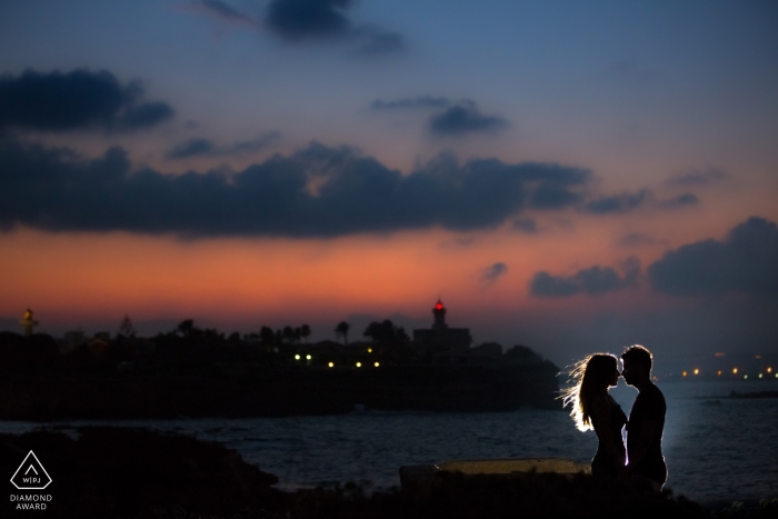 Il sole è tramontato ma la coppia è illuminata da una luce sul molo in questo servizio fotografico pre-matrimonio a Siracusa