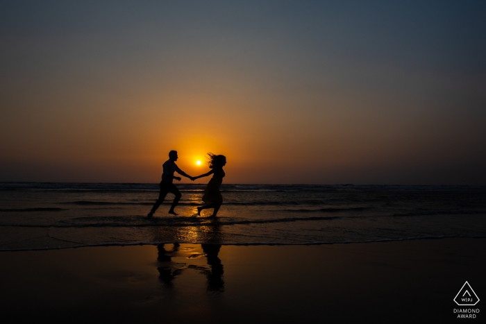 Photo by: <a href="https://www.wpja.com/photos/diamond-award-top-wedding-engagement-photographer/2509431">Sunny Pariani - Mumbai Maharashtra Maharashtra photographer with a couple frolicking on a beach in Goa as the sun sets behind them in this prewedding photo shoot
