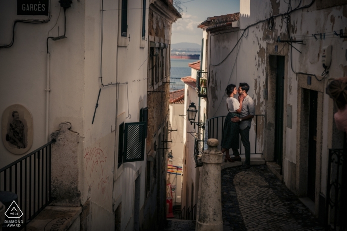 Der portugiesische Verlobungsfotograf schuf ein Bild eines Paares, das sich auf einem Balkon im Alfama-Distrikt von Lissabon küsst