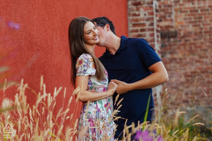 Enumclaw, fotógrafo de noivado de WA - casal beijando ao lado do edifício