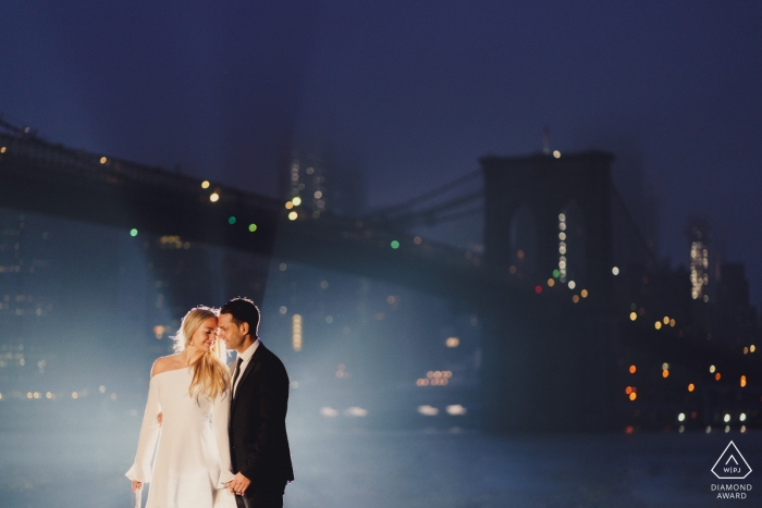 New York Couple back lit under the hudson brigde for engagement portrait