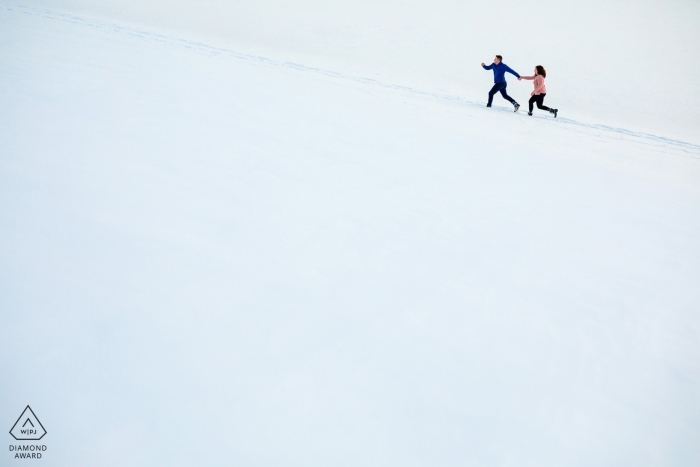 Dillon, CO sesión de compromiso con pareja corriendo en la blanca nieve