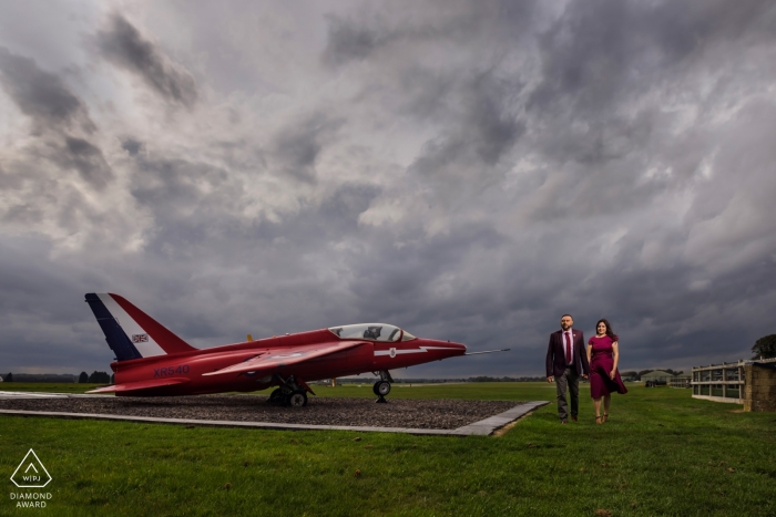 Photo by: <a href="https://www.wpja.com/photos/diamond-award-top-wedding-engagement-photographer/2531906">Jay Hoque - Uxbridge London Couple Engagement Portrait with Red Dress and Red Plane at Cotswald Airport, UK