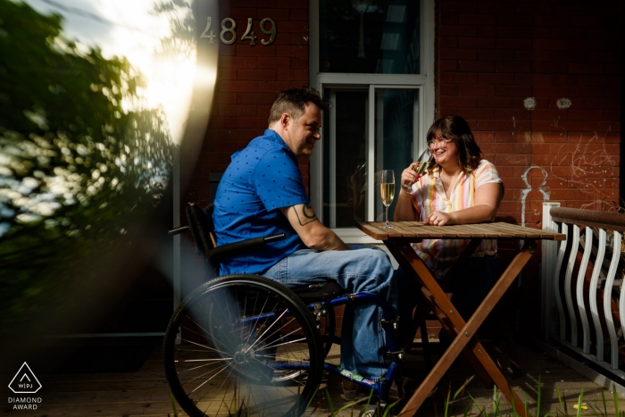  	Montreal, Quebec Engaged couple relaxing on front porch together for a portrait 