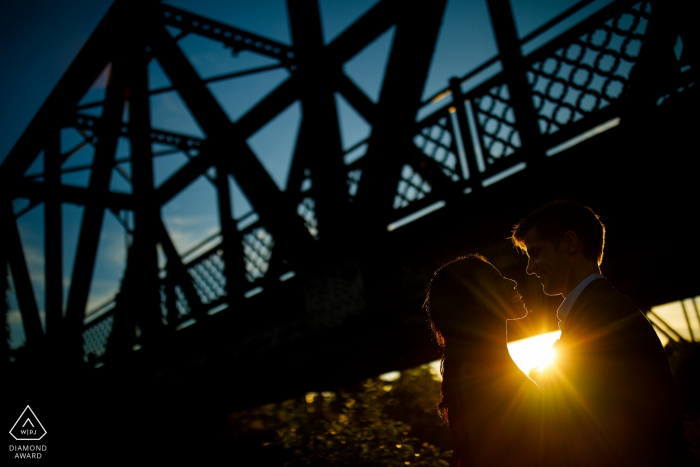 El sol se pone detrás de una pareja y el puente Wynkoop Street en Denver. Fotografía de bodas de CO