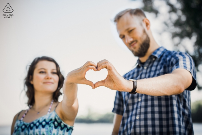 Photo: <a href="https://www.wpja.com/photos/diamond-award-top-wedding-engagement-photographer/2542679"> Piotr Maksa - Lodz Lodzkie Un couple crée un cœur avec leurs mains lors de la séance photo d'engagement de Popowo Beach
