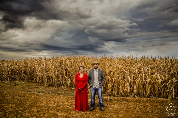 Photo by: <a href="https://www.wpja.com/photos/diamond-award-top-wedding-engagement-photographer/2542960">Alexandre Grand - Rio de Janeiro Rio de Janeiro Couple stands for an engagement portrait in the foreground of a cornfield in Goiania, Brasil.