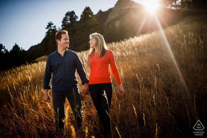 Photo by: <a href="https://www.wpja.com/photos/diamond-award-top-wedding-engagement-photographer/2543162">Trent Gillespie - Silverthorne Colorado Boulder Colorado Engagement Photography of a couple walking near the Flatirons while getting kissed by the last bit of sun.