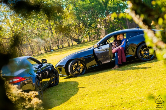 Photo by: <a href="https://www.wpja.com/photos/diamond-award-top-wedding-engagement-photographer/2543856">Vinicius Fadul - Campinas São Paulo Vinhedo couple in the car during pre-wedding portrait session on the grass.