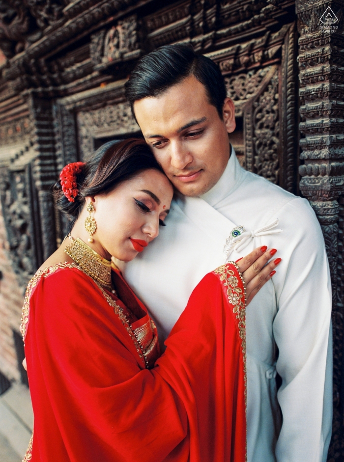 Um casal na frente de uma porta velha em Kathmandu durante o ensaio fotográfico de retrato de noivado.