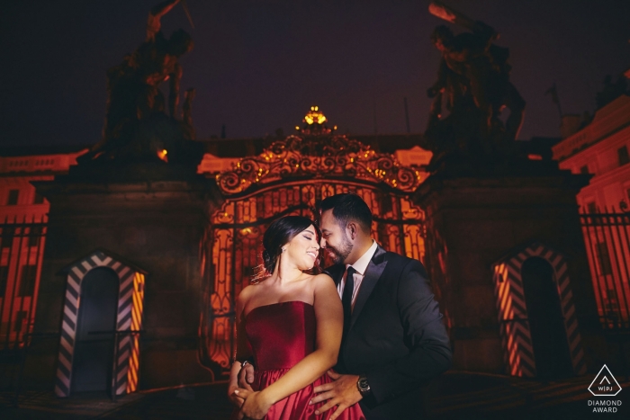 Um casal durante sua sessão de fotos de noivado muito sexy à noite no Castelo de Praga