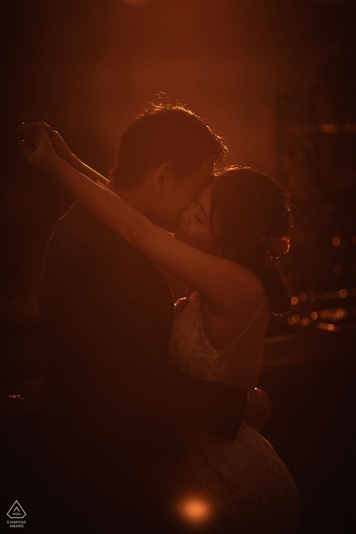 Engaged couple shares a minute together before dawn on the Charles Bridge in Prague during portrait session.