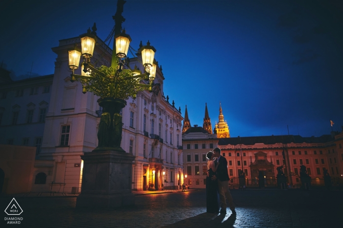 Photo by: <a href="https://www.wpja.com/photos/diamond-award-top-wedding-engagement-photographer/2544706">Kurt Vinion - Prague Hradcanske Namesti, Prague Castle, Czech Republic Pre Wedding Portraits | A couple shares a late summer night kiss underneath the impressive gas lamps at Prague Castle