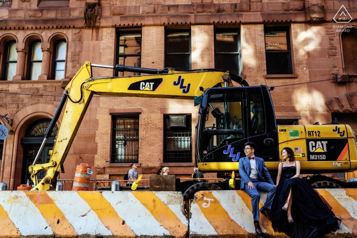 Photo: <a href="https://www.wpja.com/photos/diamond-award-top-wedding-engagement-photographer/2544725"> Wenjie Han - Long Island City à New York couple soho assis devant un engin de chantier pendant la séance de prélavage