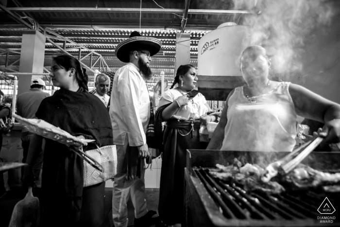 Foto von: <a href="https://www.wpja.com/photos/diamond-award-top-wedding-engagement-photographer/2545043"> Douglas Favero - Oaxaca de Juárez Oaxaca Verlobungsfotosession mit einem Paar, das den Grill am Sonntagsmarkt, Tlacolula, Oaxaca, Mexiko überprüft