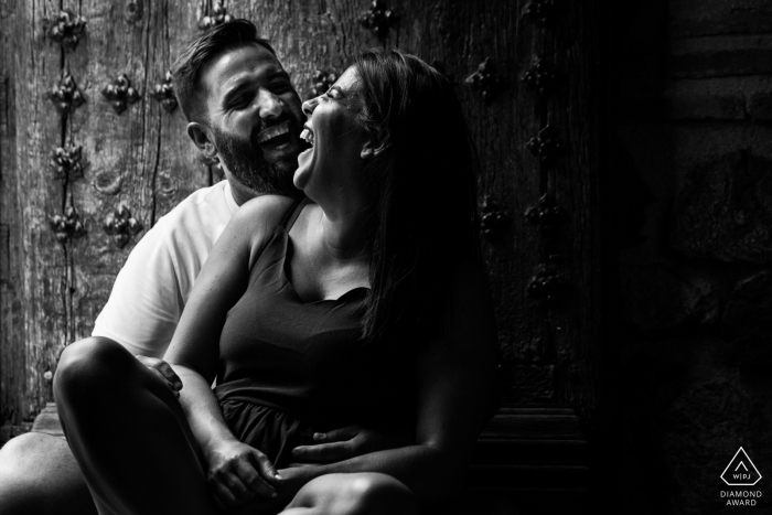 Un couple Castilla-La Mancha souriant devant la vieille porte lors d'une séance de photo de mariage à Tolède