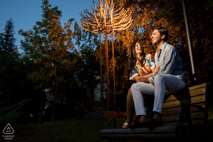 Ankara couple is sitting on a top of a bench and giggling during pre wedding photo session Bilkent University Main Campus - Ankara couple is sitting on a top of a bench and giggling during pre wedding photo session