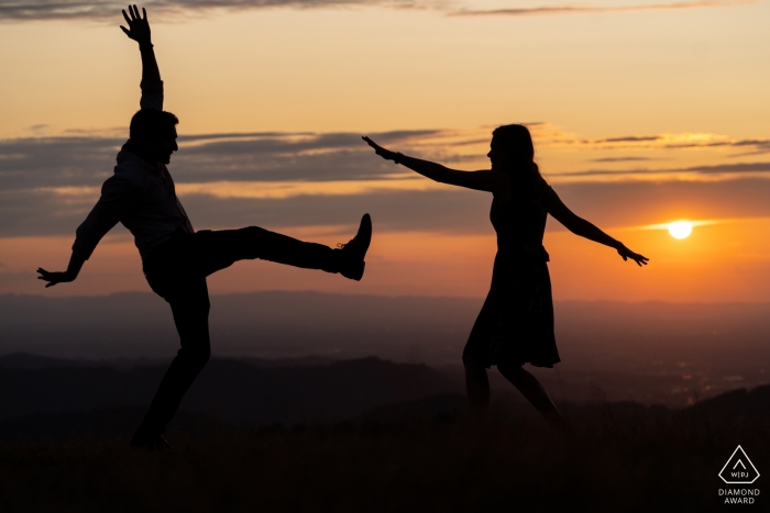Foto von: <a href="https://www.wpja.com/photos/diamond-award-top-wedding-engagement-photographer/2545585"> David Anton - Oberkirch Openau Pre Wedding Photographer - Schattenbildbild des Paartanzens lustig bei Sonnenuntergang