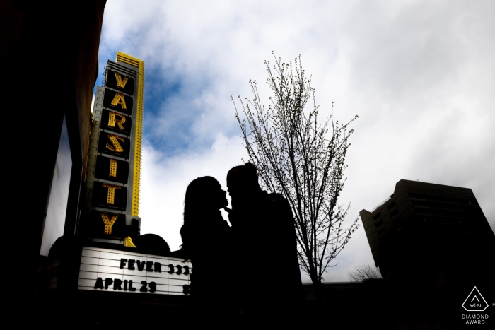 Sylwetka pary z Minneapolis przy znaku teatralnym podczas sesji portretowej zaręczynowej.