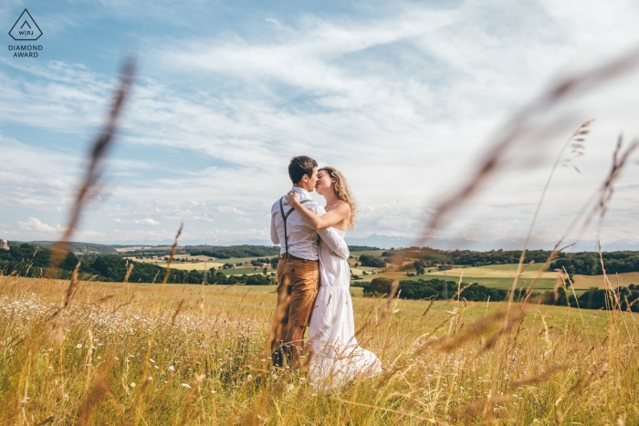 Marciac, Francia | Una pareja besándose en un paisaje durante una sesión de fotos de compromiso en la hierba