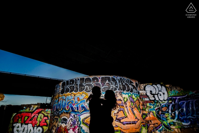 Using the graffiti to silhouette the couple with flash FDR skate park photo session | Using the graffiti to silhouette the couple with flash.