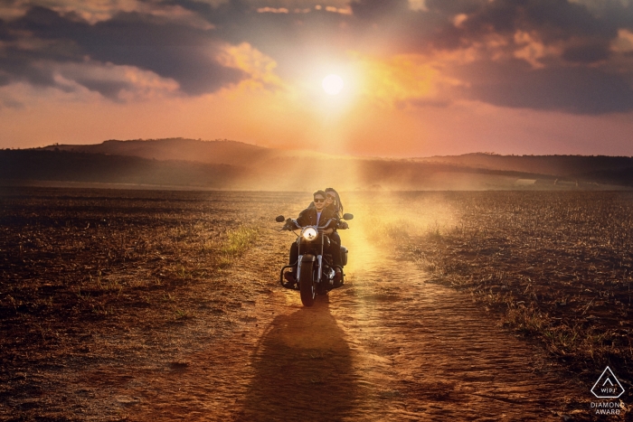 Teresópolis Pré-wedding photo shoot on a motorcycle in the desert at sunset.