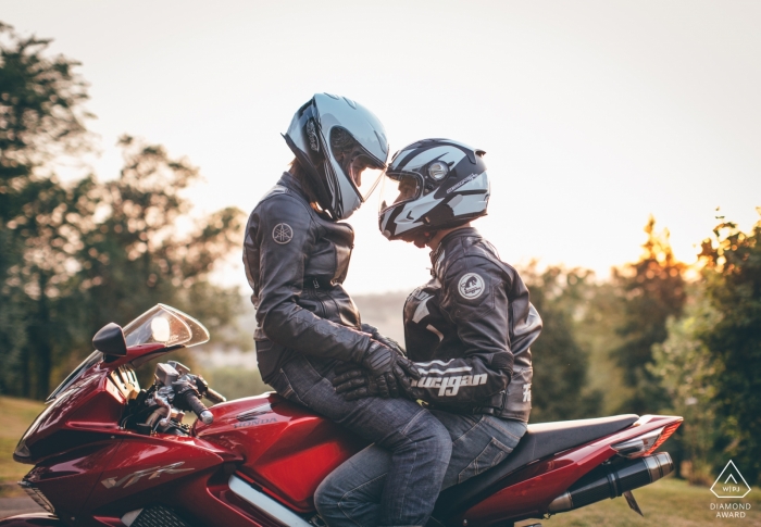 Gers, coppia di motociclisti del sud della Francia che si siede sulla bici con i caschi durante la sessione di ritratto di fidanzamento