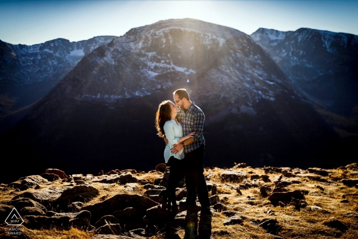 Photo by: <a href="https://www.wpja.com/photos/diamond-award-top-wedding-engagement-photographer/2547127">Trent Gillespie - Silverthorne Colorado Rocky Mountain National Park Couple Portraits | The sun peaking over the mountains to the south to create a beautiful flare of warm light for these two & their mountain engagement.