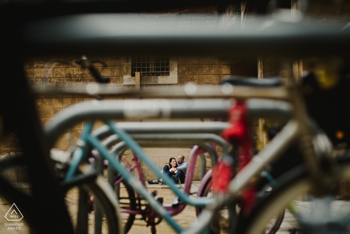 Engagement Photos from Barcelona - Image contains: sitting couple, parked bikes, light, depth of field