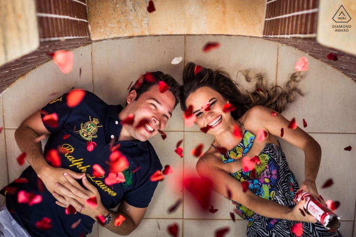 Engagement Portrait from Vicosa, Brazil | Couple laying on the ground firing hearts on the camera 