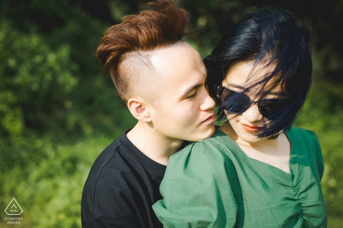 Fotos de compromiso de YUN NAN - La imagen contiene: cabello, viento, verde, posando, hierba, luz natural, pareja, gafas de sol