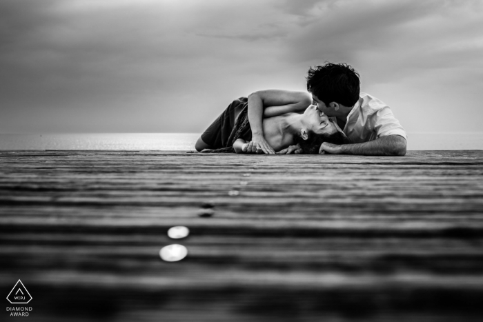 Autor zdjęcia: <a href="https://www.wpja.com/photos/diamond-award-top-wedding-engagement-photographer/2547483"> Chrystel Echavidre - Saubrigues Portret zaręczynowy z promenady w Hossegor - fotografia zawiera: parę, czarno-biały, dok, wodę, pocałunek