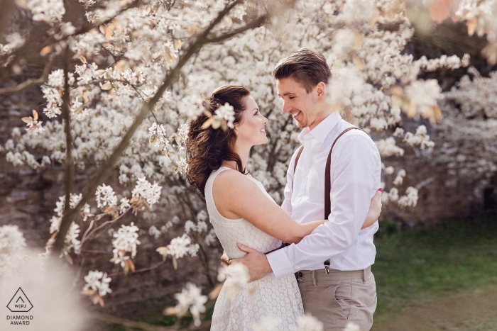 Fotos de compromiso de Rittergut Stoermede - La imagen contiene: pareja, árboles, flores, retrato, abrazo, sonrisas