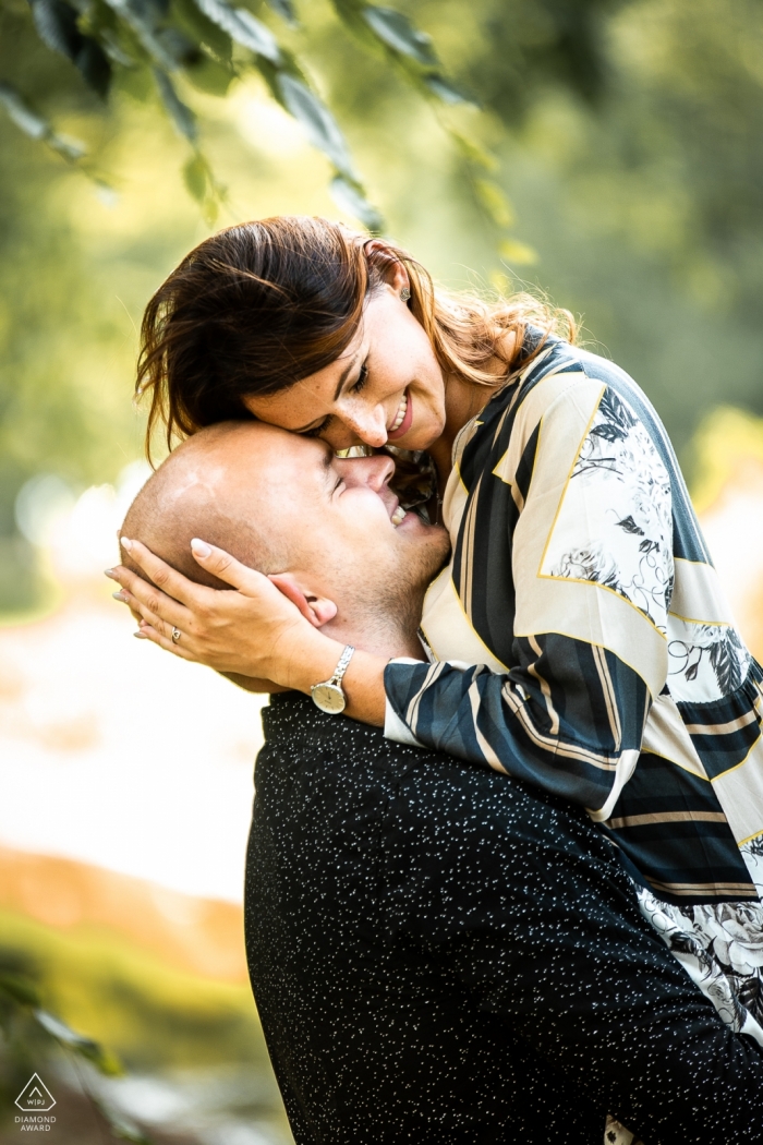 Engagement Portrait from Uniejow castle, Poland - The future groom lifts his beloved in his arms and hugs her cheek to her forehead. 