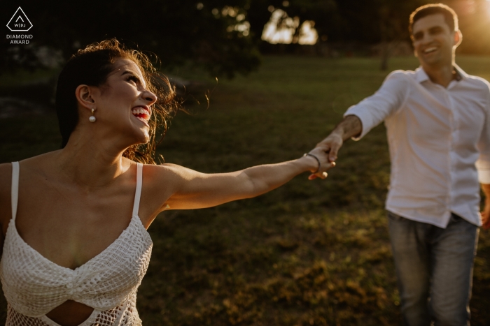 Engagement Portrait from O Butia - Porto Alegre - Rio Grande do Sul - Photography contains: couple, hands, grass, trees, park, laughing Engagement Portrait from O Butia - Porto Alegre - Rio Grande do Sul - Photography contains: couple, hands, grass, trees, park, laughing