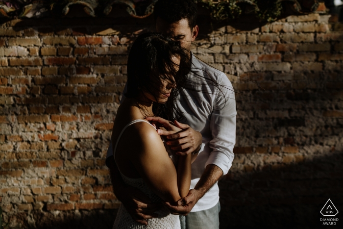 Photo by: <a href="https://www.wpja.com/photos/diamond-award-top-wedding-engagement-photographer/2548941">Renan Radici - Porto Alegre Rio Grande do Sul Engagement Photos from O Butia - Porto Alegre - Rio Grande do Sul - Portrait contains: brick, wall, shadows, couple, love session