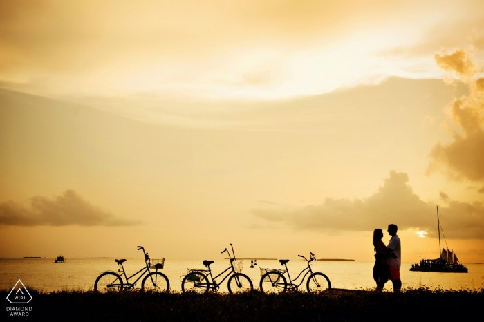 Photo by: <a href="https://www.wpja.com/photos/diamond-award-top-wedding-engagement-photographer/2549031">Julie Ambos - Key West Florida Engagement Portrait from Fort Zach, Key West - Photography contains: silhouette, couple, bicycles, water, clouds