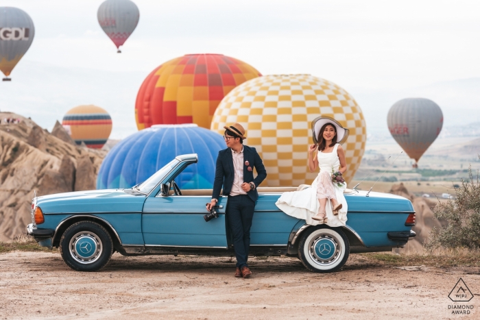 Photo by: <a href="https://www.wpja.com/photos/diamond-award-top-wedding-engagement-photographer/2549132">Mohamed Mekhamer - Istanbul Istanbul Engagement Photographer for Cappadocia, Turkey - Image contains: couple, blue, car, colorful, hot air balloons