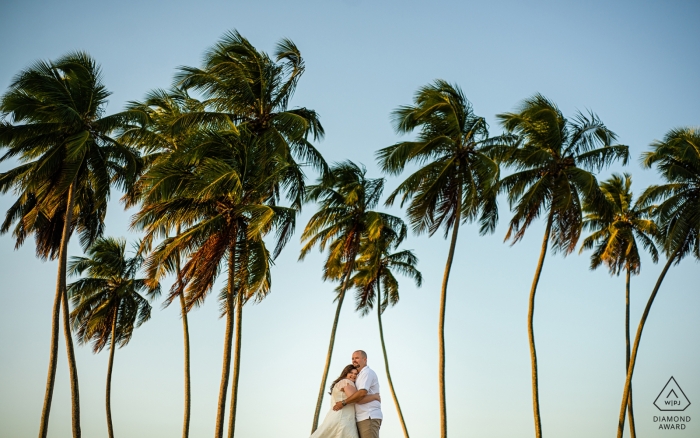 Photo by: <a href="https://www.wpja.com/photos/diamond-award-top-wedding-engagement-photographer/2550114">Monica Guimaraes - Maceió Alagoas Engagement Photos from Maceió, AL | Hugs between the coconut trees of the family beach house